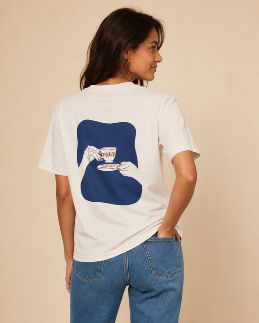 Blue Hour Tea Women's Crew-Neck Tee in Vanilla Cream, shown from the back with blue teacup artwork